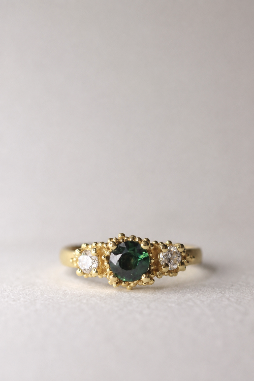 Triple cluster ring with teal sapphire