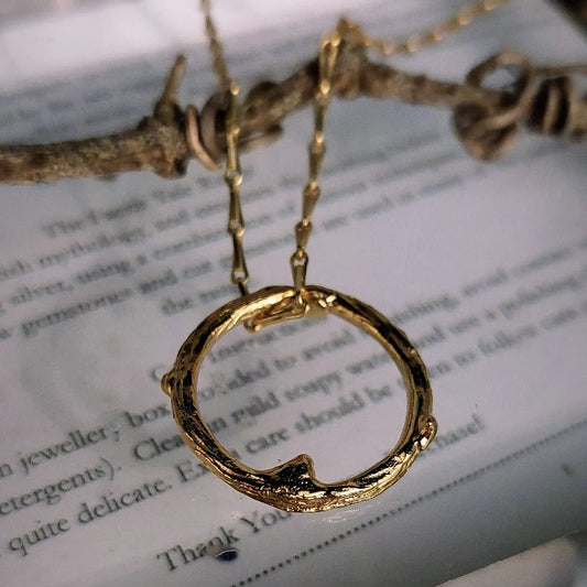 gold circle nature pendant on a gold chain