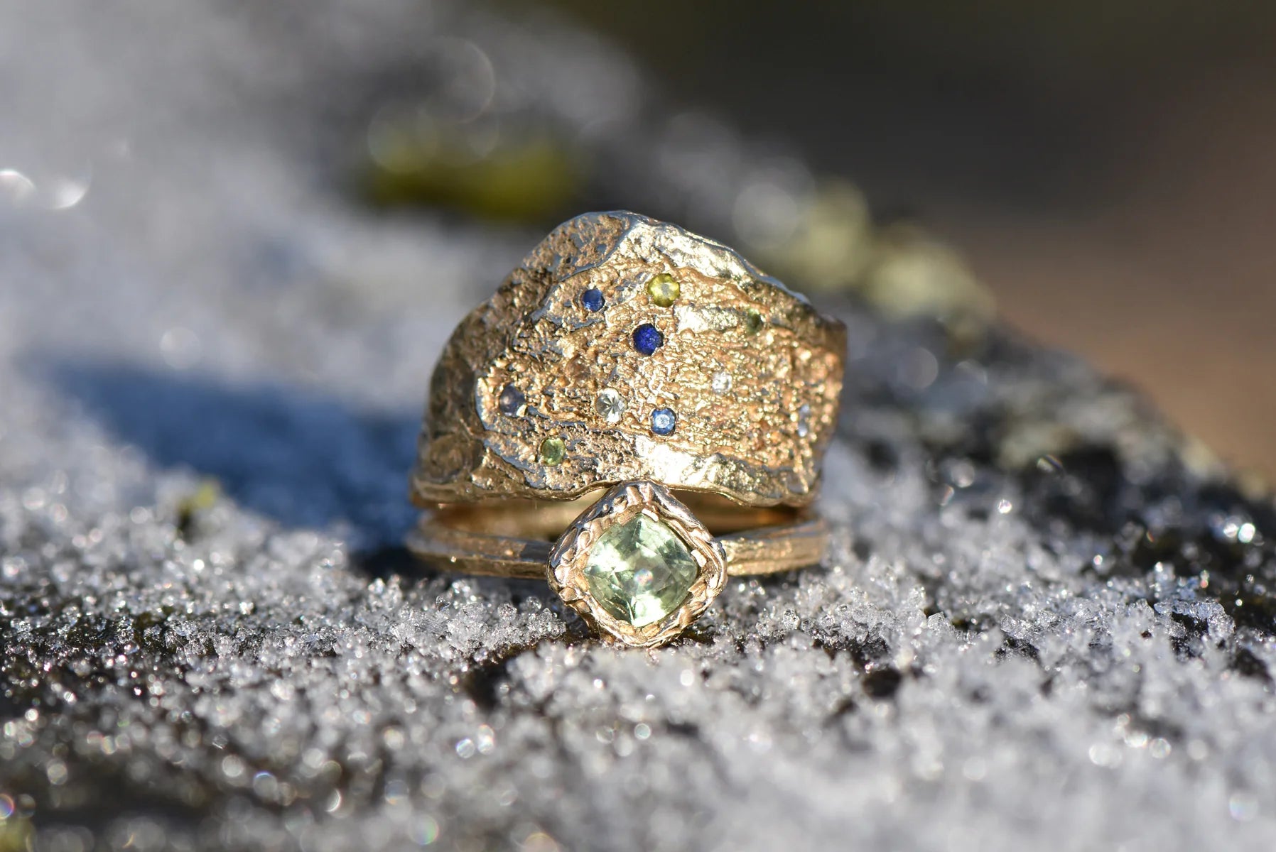 green sapphire ring stacked with another gold and sapphire ring