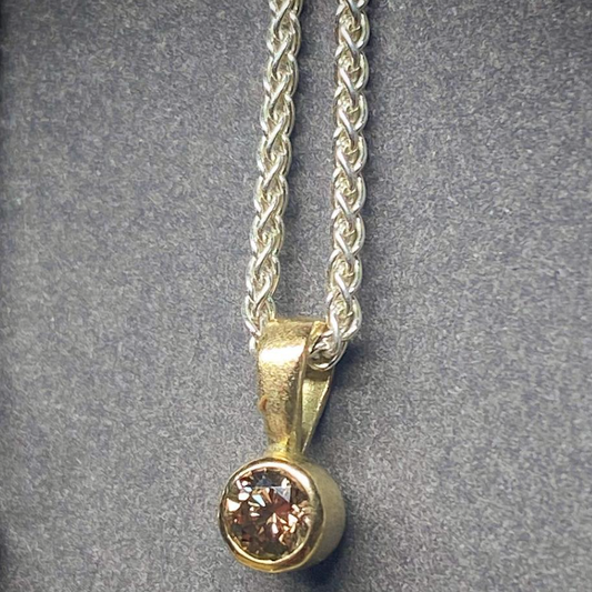 cognac diamond pendant set in gold on a silver chain