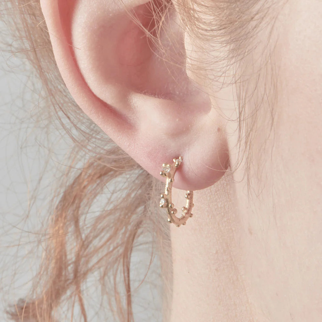 gold and diamond hoop earrings worn